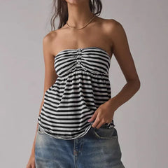Woman wearing a black and white striped strapless top with blue jeans 