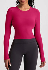 Person wearing a pink long-sleeve top and black leggings- full view