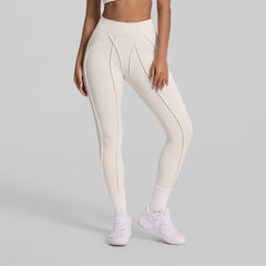 Person wearing white leggings on a gray background