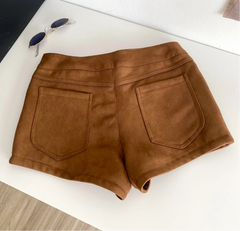Brown shorts on a white surface with sunglasses - back view