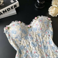 Floral lace garment on a dark surface with books and flowers in the background