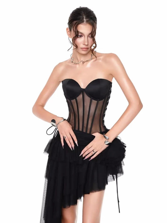 Woman wearing a black strapless dress with sheer panels 