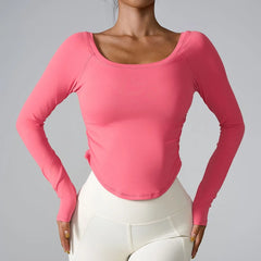 Person wearing a pink long-sleeve top and white pants on a gray background