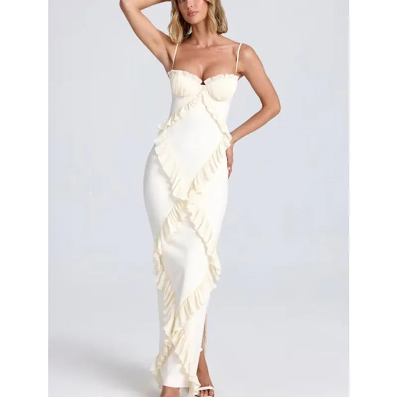 Woman wearing a white evening gown with a ruffled design on a plain background