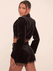 A woman wearing a black velvet blazer and shorts set, showcasing its flattering fit and elegant style.