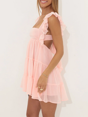 Woman wearing a pink dress with ruffled sleeves 