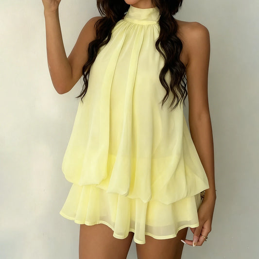 Woman wearing a light yellow dress against a plain background
