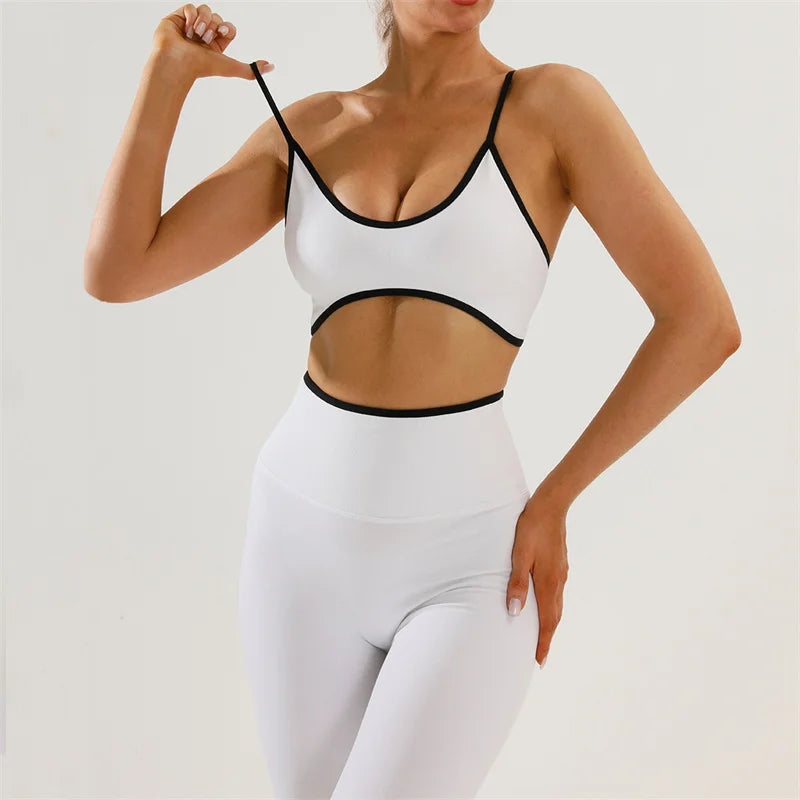 Person wearing a white sports bra and leggings with black accents