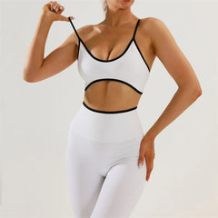 Person wearing a white sports bra and leggings with black accents