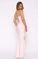 Woman wearing a light pink evening gown with a white background