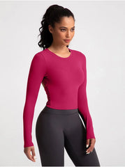 Woman wearing a pink long-sleeve top and black leggings