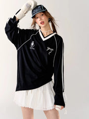 Person wearing a black long-sleeve shirt with white accents and a white skirt 