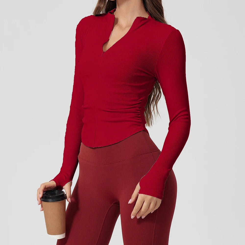 Person wearing a red long-sleeve top and leggings holding a coffee cup on a light gray background