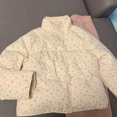 Floral-patterned quilted jacket on a gray surface