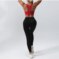 Person wearing a red sports bra and black leggings- back