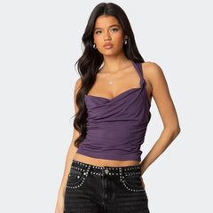 Woman wearing a purple top and black pants on a white background
