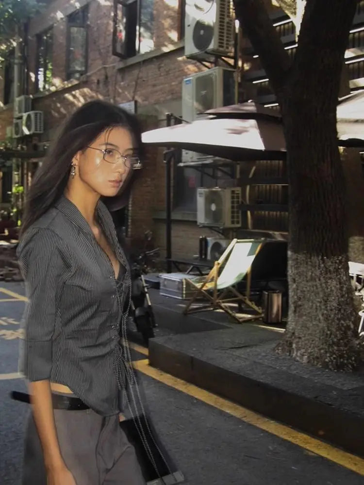 Woman walking on a city street with buildings and trees in the background