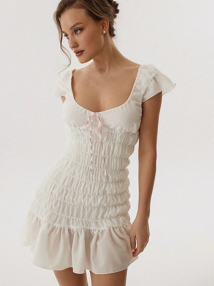 Woman wearing a white dress with ruffled sleeves
