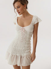 Woman wearing a white dress with ruffled sleeves