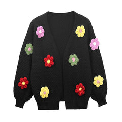 Black sweater with colorful flower patterns on a white background