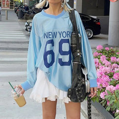 A woman wearing a blue jersey top with white skirt, showcasing its versatility and casual style.