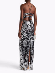 Woman wearing a black and white floral dress with a cutout back on a white background