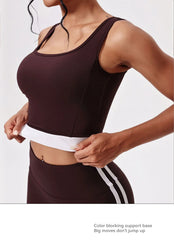 Person wearing a brown athletic outfit with white accents on a plain background