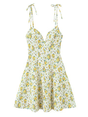A sleeveless white A-line dress with a yellow and green floral print, featuring thin tie-shoulder straps and a sweetheart neckline, shown against a plain white background.