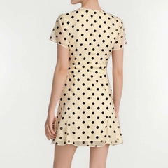 Beige dress with black polka dots on a white background