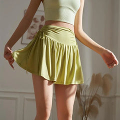Person wearing a green skirt and top in a neutral setting
