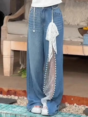 Person wearing blue jeans with a lace trim in a casual setting.