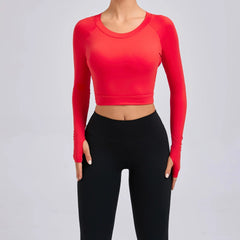 Red long-sleeve crop top and black leggings on a gray background