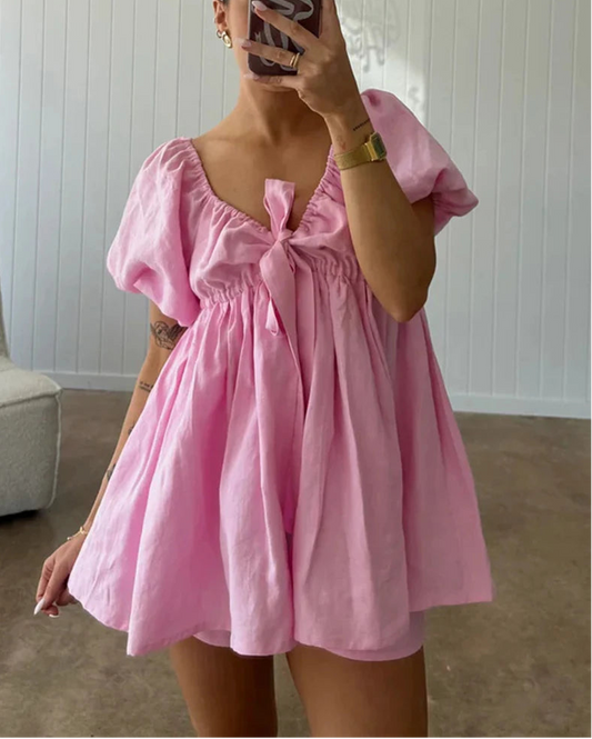 Person wearing a pink dress with a white background