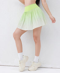 Person wearing a light green pleated skirt with white sneakers 