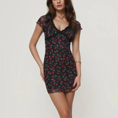 A woman wearing a flattering floral mini dress with a mesh overlay, perfect for a summer party or night out.