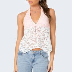 Woman wearing a pink halter top with floral lace overlay and blue jeans 