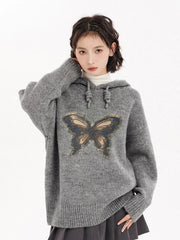 Person wearing a gray hoodie with a butterfly design