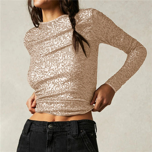 Person wearing a sparkly beige long-sleeve top against a neutral background