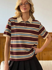 Woman wearing a striped polo shirt with a neutral background