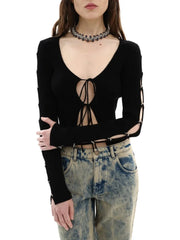 A woman wearing a black lace-up top with high-waisted jeans, showcasing its versatility and edgy style.