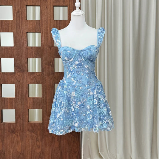 Blue mini dress with floral embroidery and sequin straps on a mannequin.