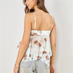 Woman wearing a floral top with thin straps against a plain background