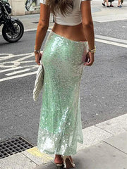 Person wearing a green sequin skirt on a city street.