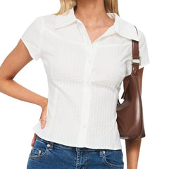 Woman wearing a white short-sleeve shirt and blue jeans, holding a brown handbag.