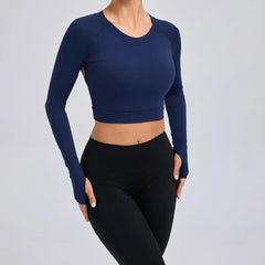 Person wearing a navy long-sleeve crop top and black leggings on a light gray background