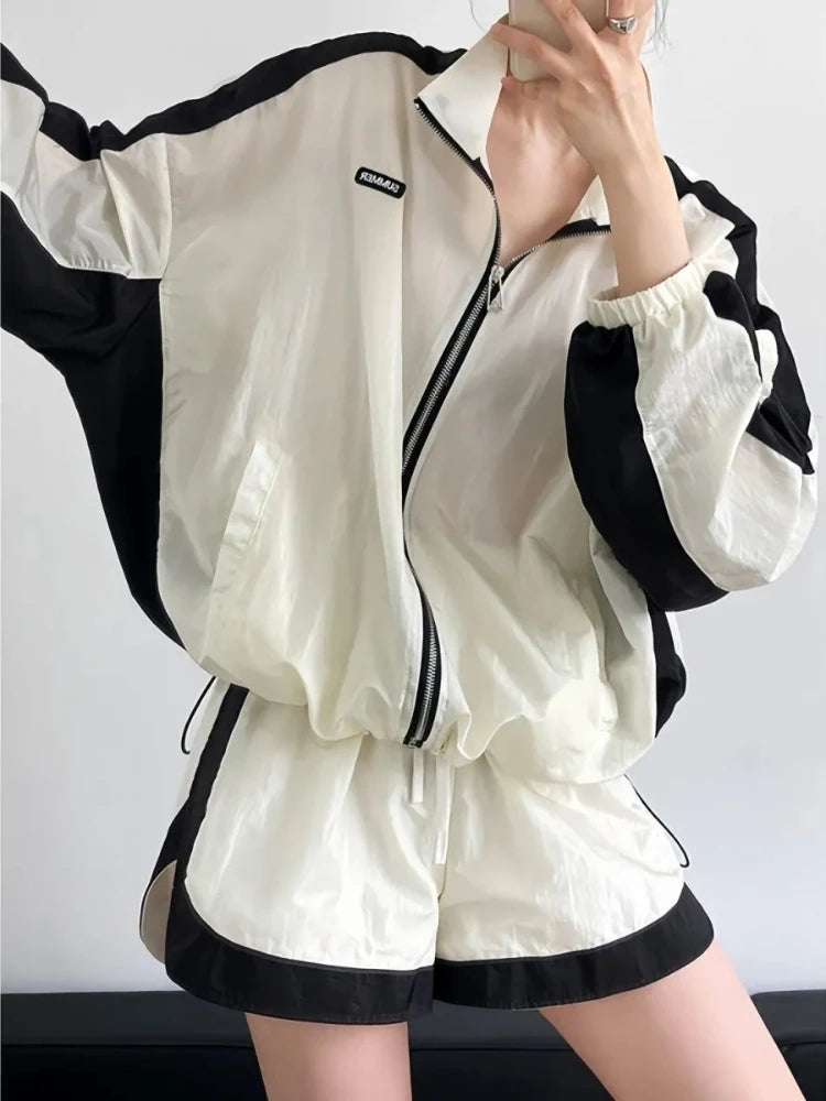 Person wearing a black and white outfit with a jacket and shorts.