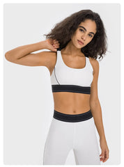 Woman wearing a white sports bra with black accents- close-up