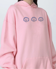Pink hoodie with blue shell designs on the chest 