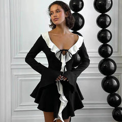 A woman wearing a flattering black mini dress with ruffle details, perfect for a party or special occasion.