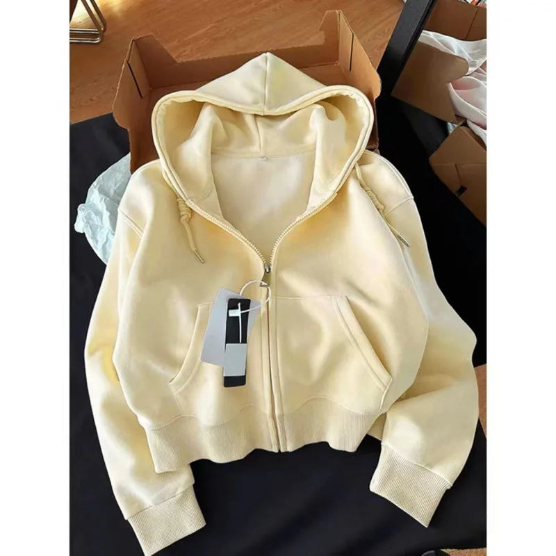 Beige hoodie with a tag on a black surface